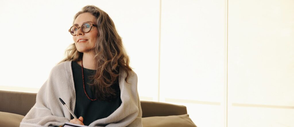 woman smiling on couch in her 50s